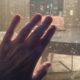 Hand rests on window screen