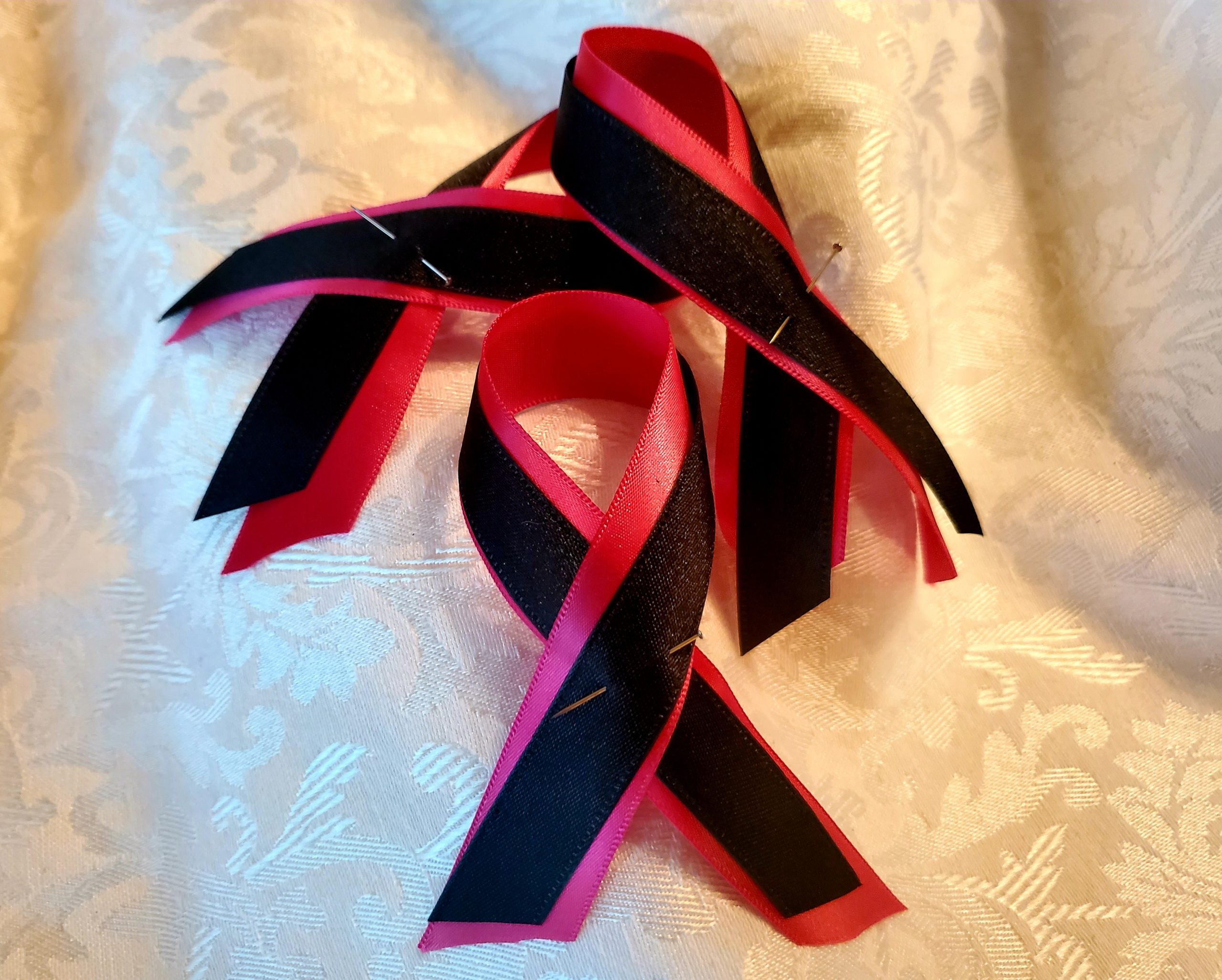 Photo of 3 pink and black mourning ribbons